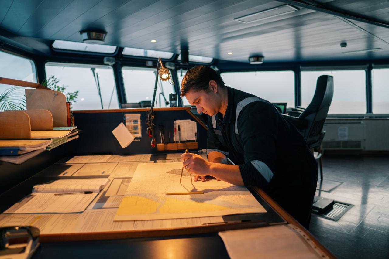 Officer at chart table on bridge
